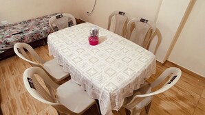 Comedor con una mesa cubierta por un mantel de encaje blanco, rodeado de cuatro sillas.