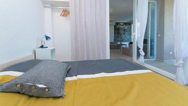 A bedroom with a bed, a bedside table with a lamp, a wardrobe, and a sliding glass door leading to a bathroom. - Villa IVKA Apartment B - sleeping 2 to 4,  specious living area, gorgeous views (Brela)
