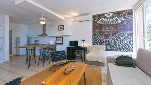 A modern living room with a wooden coffee table, a sofa, and a dining area with a table and chairs. - Villa IVKA Apartment B - sleeping 2 to 4,  specious living area, gorgeous views (Brela)