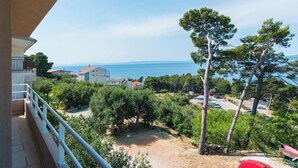 A balcony with a view of a coastal area, including trees and buildings. - Villa IVKA Apartment B - sleeping 2 to 4,  specious living area, gorgeous views (Brela)