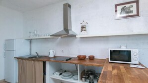 A compact kitchen with a wooden countertop, a built-in stove, a microwave, and a stainless steel range hood. - Villa IVKA Apartment B - sleeping 2 to 4,  specious living area, gorgeous views (Brela)