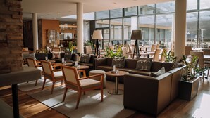 Un hall d’entrée spacieux, doté de meubles modernes, de grandes fenêtres et d’une variété d’espaces de détente.