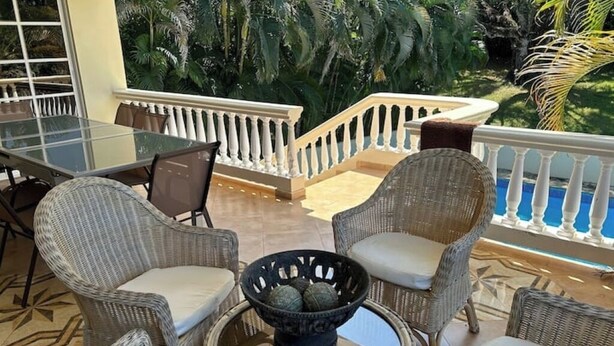 A balcony with wicker furniture, a glass table, and a decorative bowl. - 2nd Visit Guaranteed (Sosúa)
