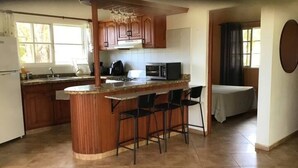 A kitchen with a central island, bar stools, a microwave, and a stove. - 2nd Visit Guaranteed (Sosúa)
