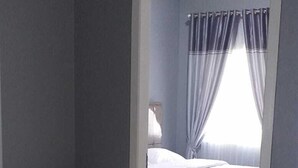 A bedroom with a bed, a desk, and a mirror. - Pintu Waluh Homestay (Takengon)