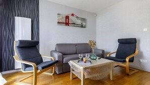 Una sala moderna con dos sillones, un sofá y una mesita de centro.