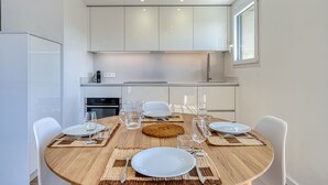 A modern kitchen with white cabinets, a stainless steel sink, and a window. - Chez NiLo - 5min de la Plage (Veyrier-du-Lac)