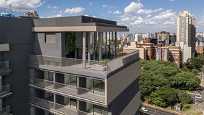 A modern building with a glass balcony and a view of the cityscape.