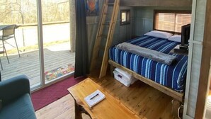 A cozy cabin with a bunk bed, wooden furniture, and a large window. - Cherry Treesort "Big Nick" (Rowan County)