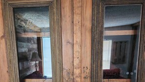 A wooden double door with intricate carvings and a glass panel.