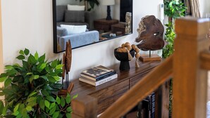 A wooden console table with a mirror, books, and decorative items.