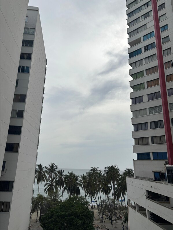 A high-rise building with multiple floors, large windows, and a red vertical stripe.