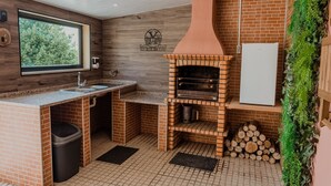 Een compacte keuken met een bakoven, een spoelbak en een raam met uitzicht op groen.