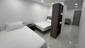 A modern hotel room with two beds, a wardrobe, and a small seating area. - D&X Apartment-H | 2-Bed, Kitchen, AC, WiFi, TV (Kralendijk)