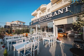 A restaurant with outdoor seating, a balcony, and a sign stating 'Traditional of Albania.'