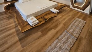 A modern hotel room with a wooden headboard, a large mirror, and a wooden floor. - Eros Hotel (Ksamil)