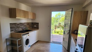 A modern kitchen with a built-in washing machine, a sink, and a countertop. - Guest House in Allauch (Allauch)