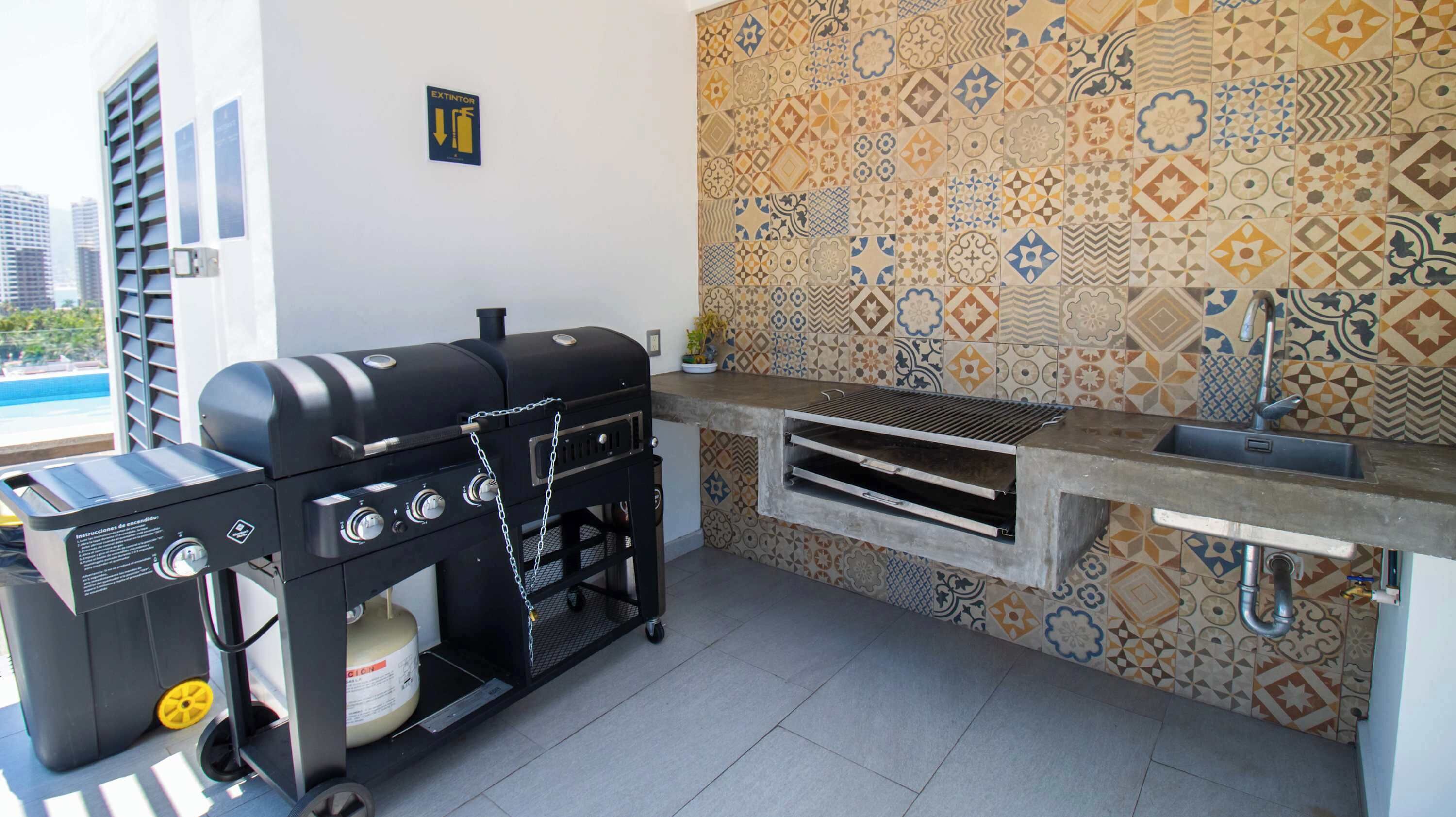 An outdoor kitchen with a grill, a gas cylinder, and a sink.