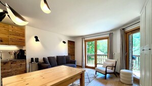 Een moderne keuken met houten kastjes, een eettafel en een bank. Een grote schuifpui leidt naar een terras.