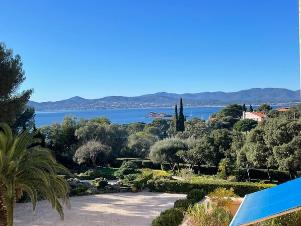 A coastal landscape with a clear view of the sea and distant mountains.