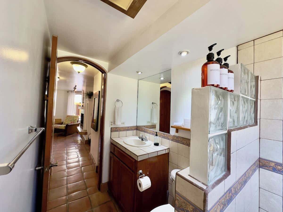 Een badkamer met een wastafel, spiegel en toiletartikelen.