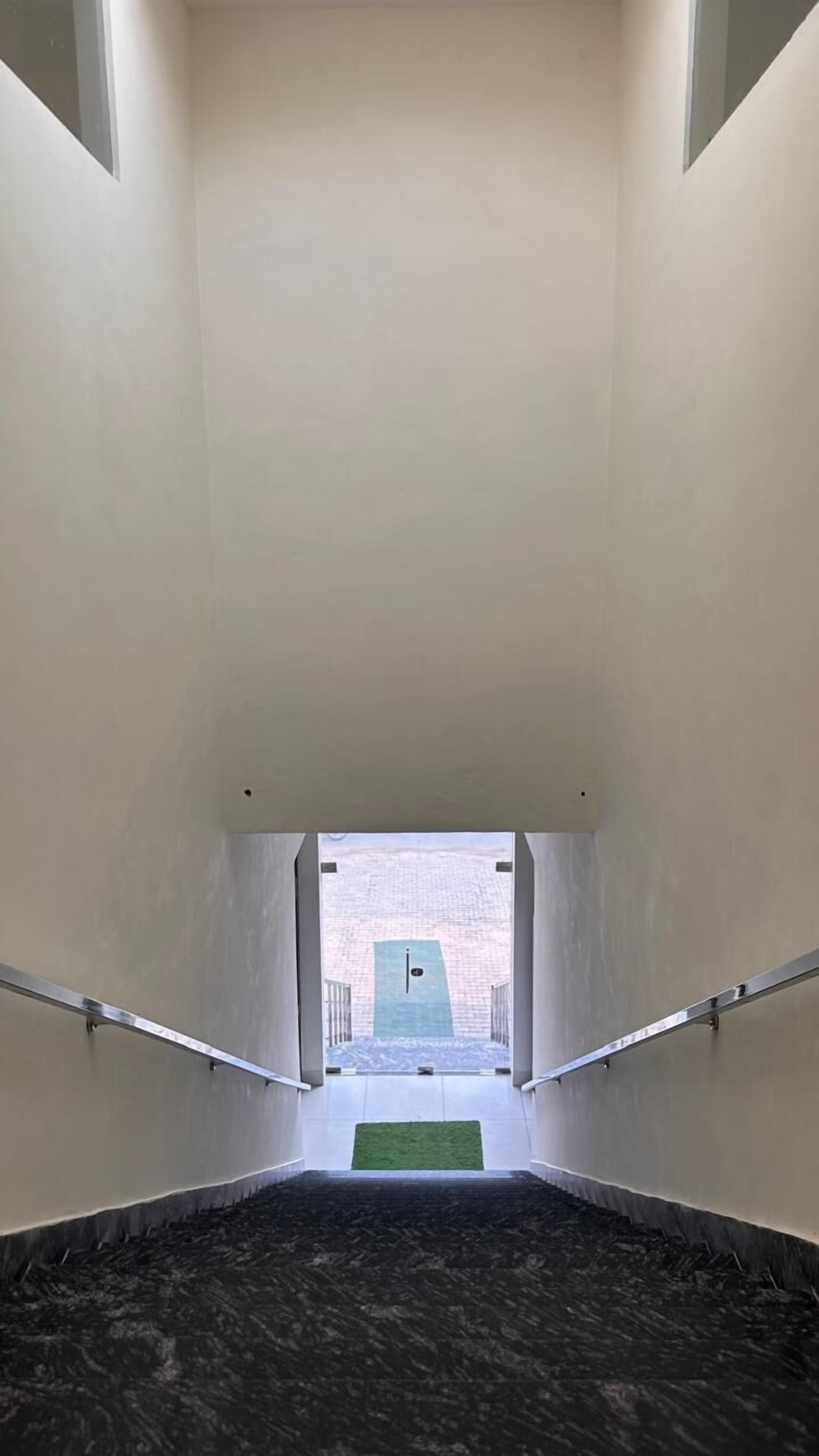 A staircase leading to a rooftop terrace with a view of a brick building.