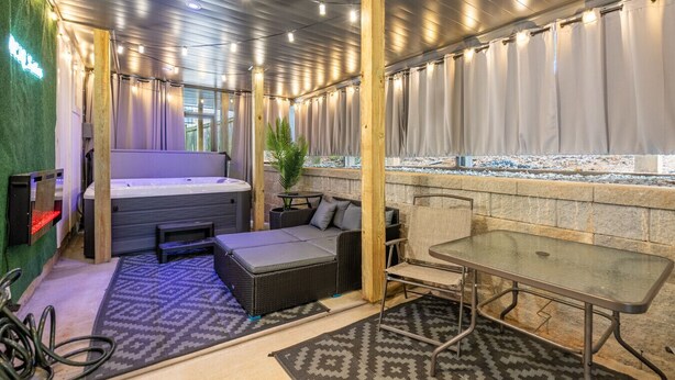 A spa area with a hot tub, seating, and a table.