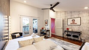 A modern bedroom with a bed, a desk, and a chair. - The Dolly Den! • Murals and Glam | Private Rooftop (Nashville)