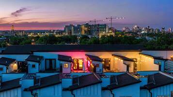 Un barrio residencial con varias casas, algunas con balcones a la vista y un edificio destacado con entrada iluminada en rosa.
