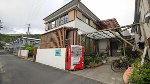 A residential building with a vending machine, a bicycle, and potted plants. - Guest House Aman (Amami)