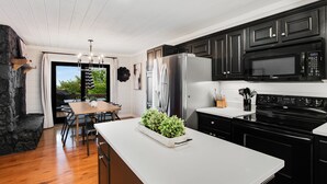 A modern kitchen with dark cabinets, a white countertop, and a built-in stove. - Discover Modern Luxe Vibes • HotTub • PoolTable • Secluded (Blue Ridge)