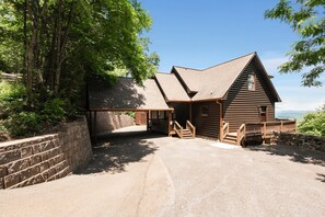 A log cabin with a stone retaining wall, wooden steps, and a view of the landscape. - Sunrock Chalet: Discover Modern Luxe Vibes • Hot-Tub • Pool Table • Epic Views (Blue Ridge)