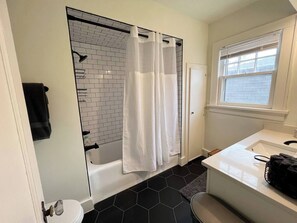 A bathroom with a shower, toilet, and sink.