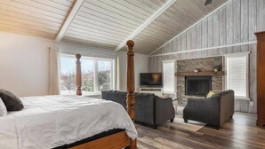 Ein Schlafzimmer mit einem Himmelbett, zwei Sofas, einem Kamin und einem Fernseher.