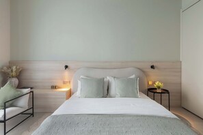 A modern bedroom with a large bed, two bedside tables, and a nightstand.