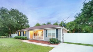 A single-story house with a front porch, a satellite dish, and a well-maintained lawn.