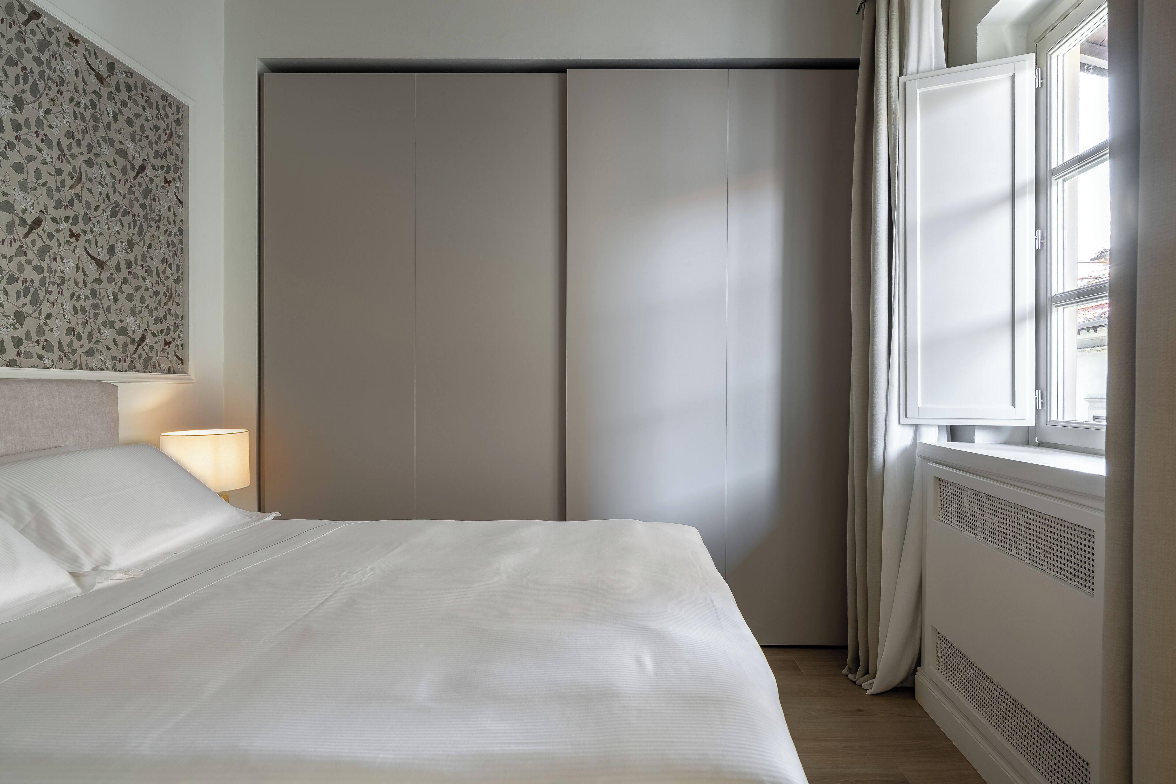 Un llit ben fet amb roba de llit blanca en una habitació d'hotel.