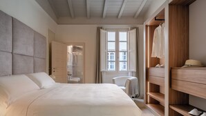 Un dormitorio con cama, armario y ventana.