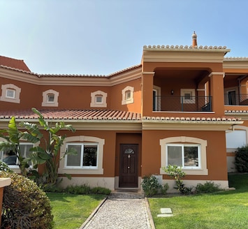 Front of linked villa with pretty garden