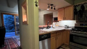 Una cocina con gabinetes de madera, electrodomésticos de acero inoxidable y un ventanal grande.