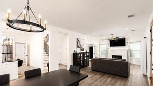 A modern kitchen with a dining area, a living room, and a staircase. - The Perfect Getaway! Insta:Thewhitehouse._ (San Antonio)