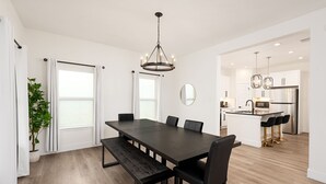 A modern kitchen with a central island, white cabinetry, and stainless steel appliances. - The Perfect Getaway! Insta:Thewhitehouse._ (San Antonio)