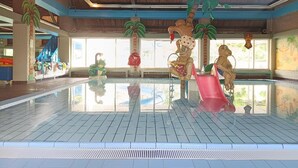 En inomhuspool med dekorativa palmer och en vattenrutschkana.
