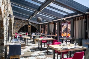 An indoor dining area with stone walls, wooden tables, and red chairs. - Wifi, 200m from resort center, balcony, tv, ski locker, 45m², Tignes (Tignes)