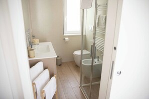 Een douche, een haardroger, een bidet, handdoeken