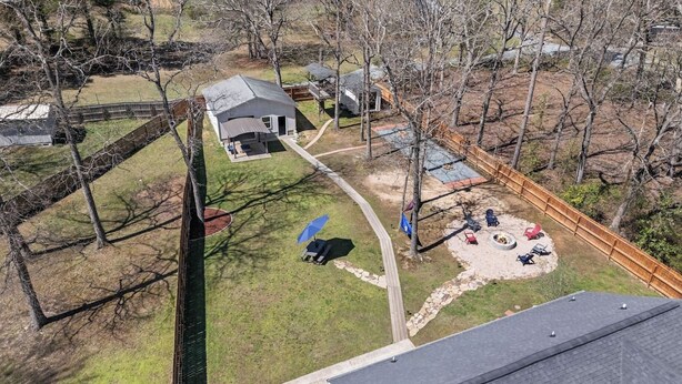 A residential area with a fenced backyard, a fire pit, and a lawn. - Charming 3-bedroom Home in Monroe with a Pool Table and Fire Pit, WiFi (Monroe)