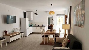A modern living room with a sofa, TV, dining area, and kitchen. - Antonio Parra I Tourist Apartments (Unknown)