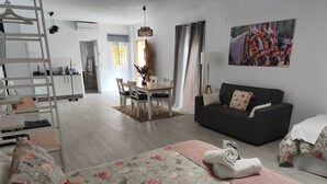 A modern living room with a sofa, a dining table, and a black sofa. - Antonio Parra I Tourist Apartments (Unknown)