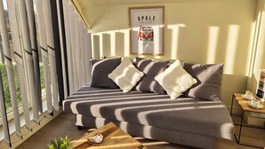 A modern living room with a grey sofa, a wooden coffee table, and a framed picture on the wall. - The Sleeping Room (BERTHEN)