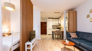 A modern living room with a TV, sofa, coffee table, and wooden accents.